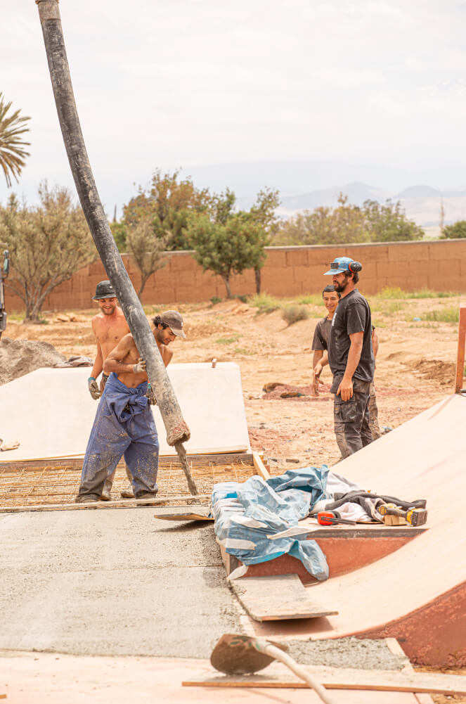 Hanota pouring concrete from the pump during the Fiers et Forts Skatepark construction in Morocco
