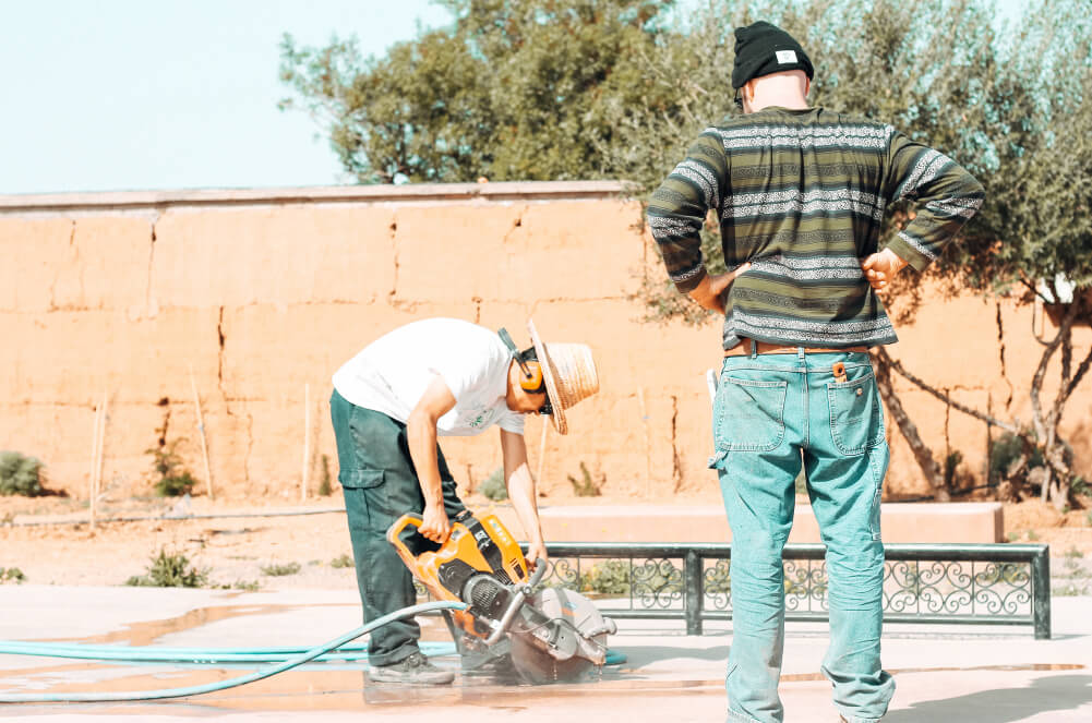 Teacher explaining how to cut concrete safely at Fiers et Forts Skatepark in Morocco