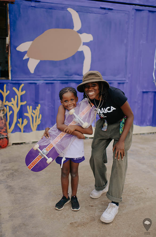 Kayla Wheeler giving a skateboard to a young Jamaican girl at the Freedom Skatepark