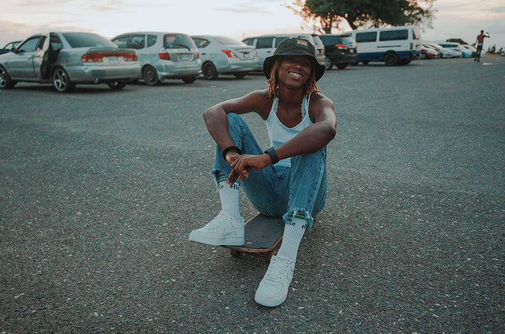 Kayla sitting on a skateboard in Kingston, Jamaica