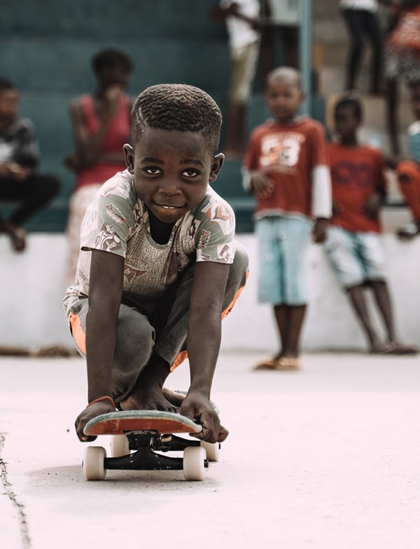 Angolan child on a skateboard during an Edu-Skate class