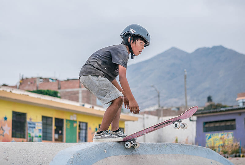 child dropping a ramp on a skateboard