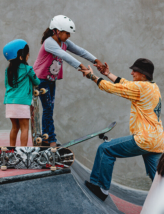 Skatebaording teacher helping a girl to drop a ramp during a Girl Skate Sessions at the Cerrito's Skatepark in Peru.
