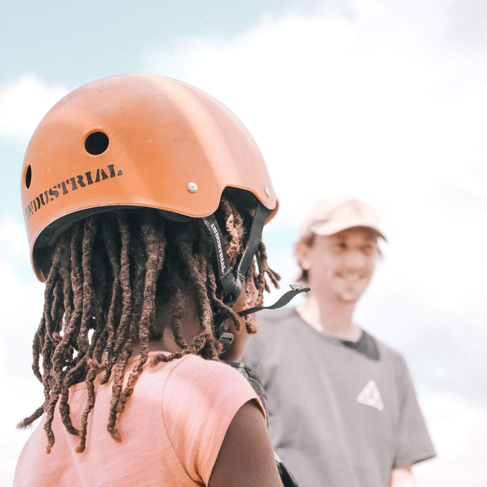 Girl in Jamaica putting a skateboarding helmet on
